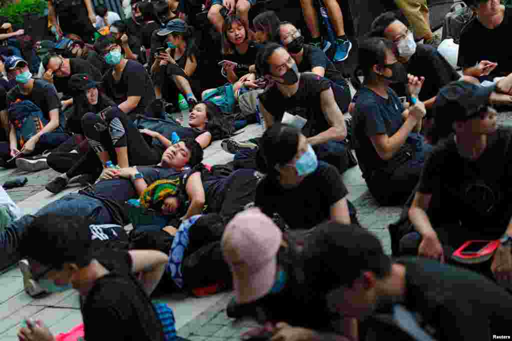 示威者2019年6月21日在香港舉行的示威活動中坐著或躺在地上，他們要求香港領導人下台並撤回引渡法案。