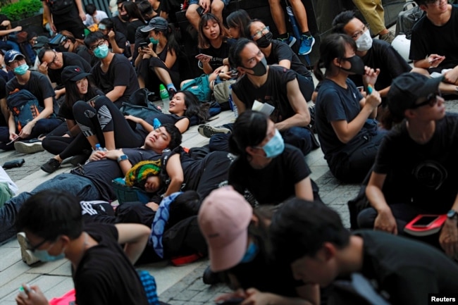 示威者2019年6月21日在香港举行的示威活动中坐在或躺在地上，他们要求香港领导人下台并撤回引渡法案。