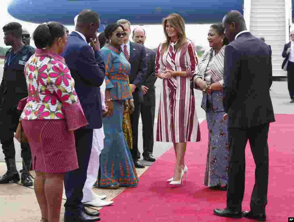First lady Melania Trump walks with Ghana's first lady Rebecca Akufo-Addo, second from right, and Samuel Kumah, Chief of Protocol, right, during an arrival ceremony at Kotoka International Airport in Accra, Ghana, Oct. 2, 2018.