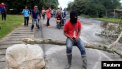 FILE - Indigenous people protest against the goverment, demanding land reform and increased state spending in rural areas, at the Panamerican highway in Mondomo, Cauca, Colombia, June 3, 2016.