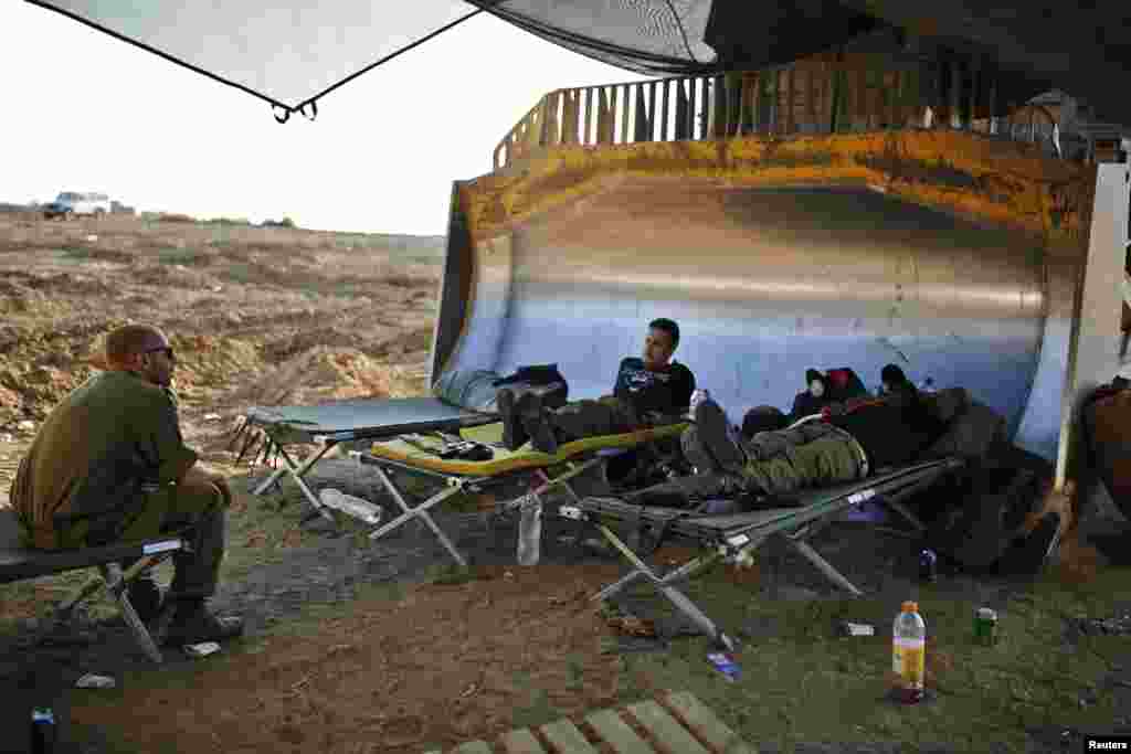 Israeli soldiers rest at a staging area near the border with the Gaza Strip, Aug. 7, 2014.