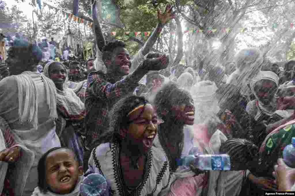 Ethiopian Orthodox worshippers get sprinkled with water in the compound of Fasilides Bath during the celebration of Timkat, the Ethiopian Epiphany, in the city of Gondar.