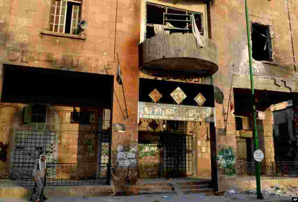 In this citizen journalism image provided by Edlib News Network ENN, a Syrian man walks past a destroyed building in Maarat al-Numaan on the eastern edge of Idlib province, Syria, July 28, 2012.