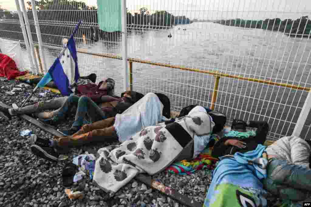 Migrants rest in the border of Guatemala and Mexico, in Ciudad Tecun Uman, Guatemala, Oct. 21, 2018.
