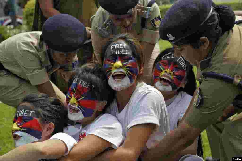 Tibetan exiles shout slogans as they are detained by police during a protest outside the Chinese embassy in New Delhi, India.