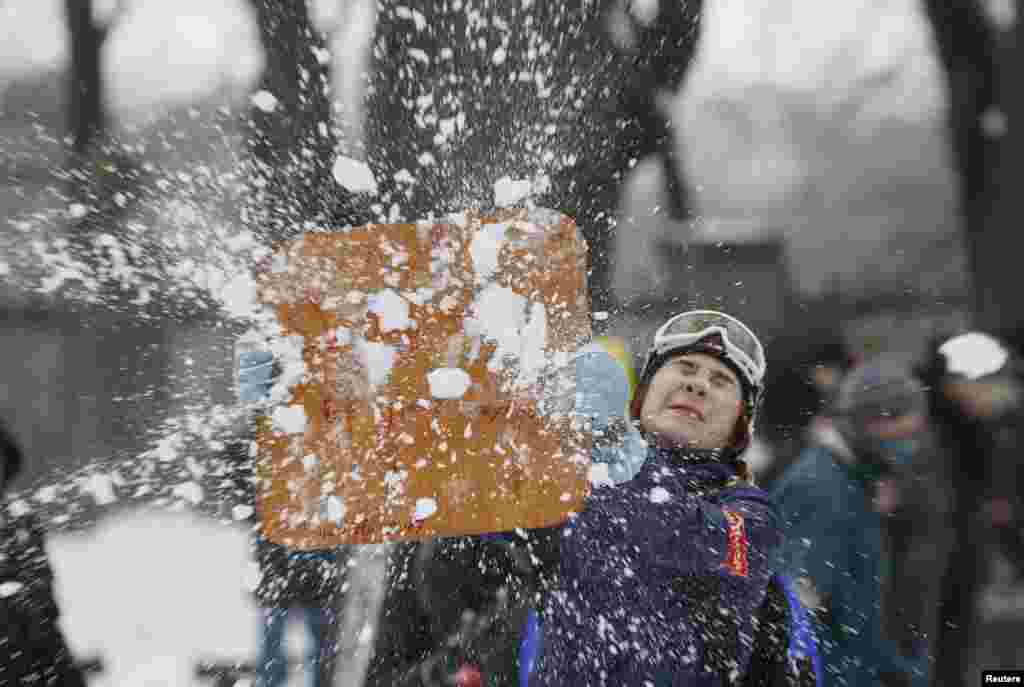 A woman enjoys a flash mob snowball fight in Kyiv, Ukraine, Jan.14, 2017.