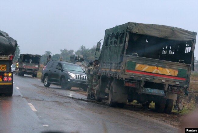 Soldiers stand beside military vehicles just outside Harare, Zimbabwe, Nov. 14, 2017.