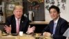 Presiden AS Donald Trump (kiri) berbicara dengan PM Jepang Shinzo Abe di restoran Inakaya, Roppongi, Tokyo Minggu (26/5). 