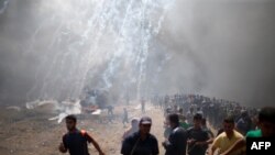 Des manifestants palestiniens lors d'une manifestation contre l'ambassade américaine à Jérusalem, à la frontière entre Israël et Gaza à l'est de la ville de Gaza, le 14 mai 2018.