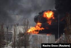 Petugas pemadam kebakaran berusaha memadamkan api di kilang minyak di dekat kota pelabuhan Odesa, akibat rudal, di Ukraina, 3 April 2022. (Foto: REUTERS/Nacho Doce)