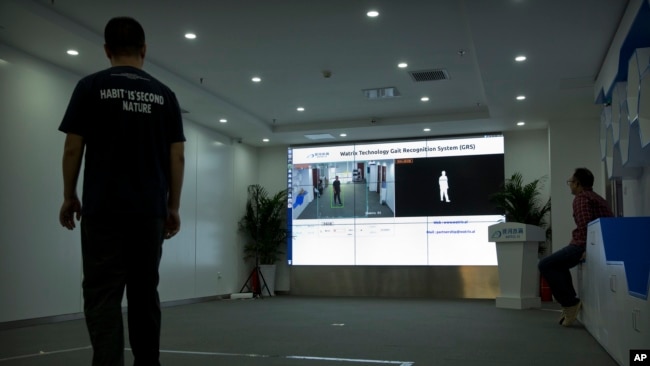 In this Oct. 31, 2018, photo, a Watrix employee walks around to let the company's gait recognition software to recognize his walking during a demonstration at their company's offices in Beijing, China. (AP Photo/Mark Schiefelbein)