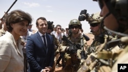 French President Emmanuel Macron, center, and Defense Minister Sylvie Goulard meet soldiers of Operation Barkhane, France's largest overseas military operation, in Gao, northern Mali, May 19, 2017.