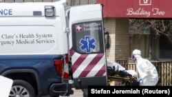 Dalam ilustrasi, petugas kesehatan memasukkan seorang pasien ke ambulans di Pusat Rehabilitasi dan Rehabilitasi Andover, selama wabah corona di Andover, New Jersey, AS, 16 April 2020. (Foto: Reuters/Stefan Jeremiah)