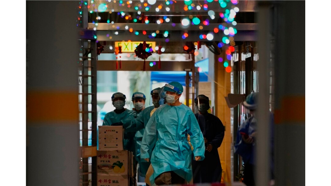 Petugas kesehatan mengenakan APD berjalan di kawasan Kwai Chung Estate di Hong Kong, yang lockdown di tengah merebaknya virus COVID-19,Sabtu, 22 Januari 2022.