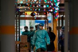 Petugas kesehatan mengenakan APD berjalan di kawasan Kwai Chung Estate di Hong Kong, yang lockdown di tengah merebaknya virus COVID-19,Sabtu, 22 Januari 2022.