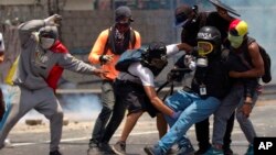 Los manifestantes ayudan a un periodista que se lesionó en una pierna mientras cubrían los enfrentamientos entre manifestantes y la Guardia Nacional Bolivariana durante una protesta en Caracas, Venezuela, el lunes 10 de abril de 2017.