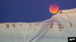 A super blue blood moon behind a mountain is seen from Longyearbyen, Svalbard, Norway, on January 31, 2018.