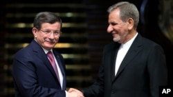 Iranian Vice President Eshagh Jahangiri, right, and Turkish Prime Minister Ahmet Davutoglu shake hands at the conclusion of their joint press conference at the Saadabad Palace in Tehran, Iran, March 5, 2016.