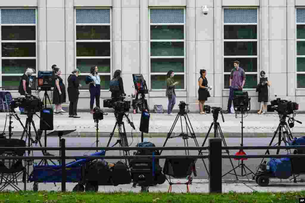 Television crew equipment is set up across the street as reporters and people line up outside Brooklyn Federal court for opening statements in R&amp;B star R. Kelly&#39;s long-awaited federal trial in New York, which comes following years of accusations that he sexually abused women and girls.