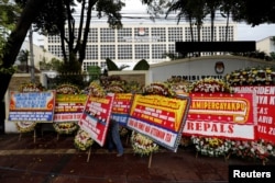 FILE - A worker arranges flower wreaths and congratulatory boards from people after this week's election outside General Election Commission (KPU) headquarters in Jakarta, Indonesia, Apr. 21, 2019.