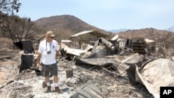 Steve Keeling walks through the ashes of his fire ravaged home in South Lake, California, June 27, 2016. 