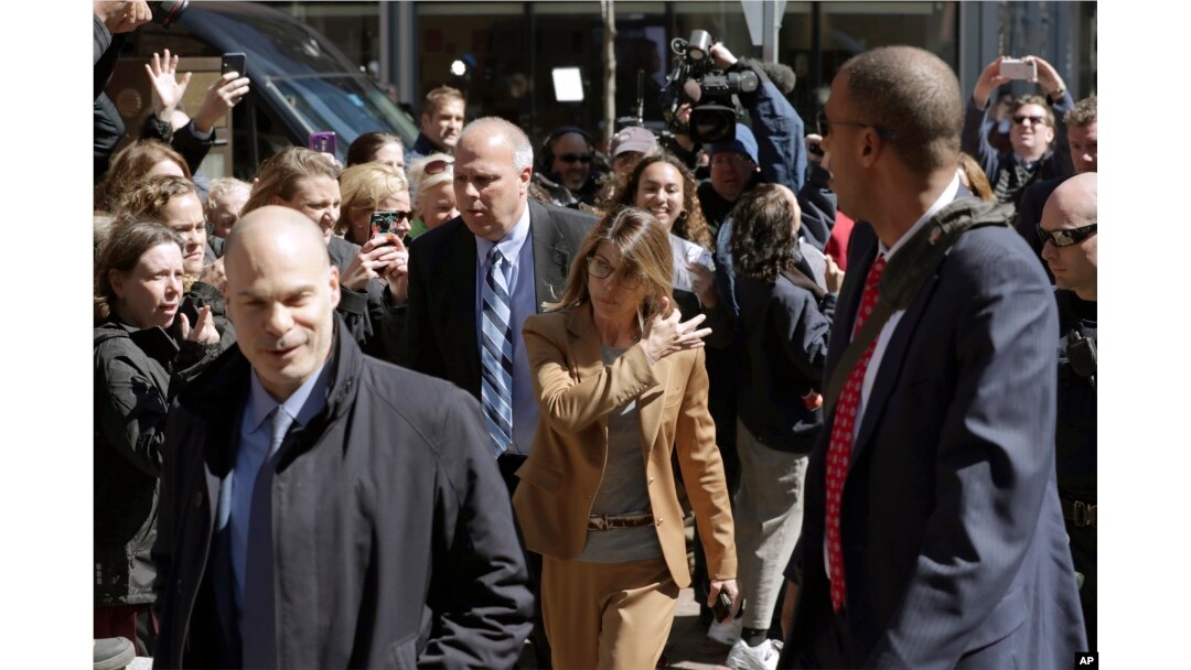 FILE - Fans photograph actress Lori Loughlin as she arrives at federal court in Boston, April 3, 2019, to face charges in a nationwide college admissions bribery scandal.