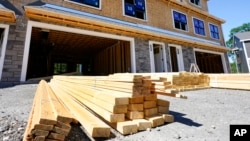 FILE - Lumber sits in stacks at a construction site in Middleton, Massachusetts, June 24, 2021. President Donald Trump on Saturday ordered a new trade investigation that could heap more tariffs on imported lumber.