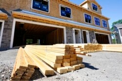 In this June 24, 2021 photo, lumber is piled at a housing construction site in Middleton, Mass.