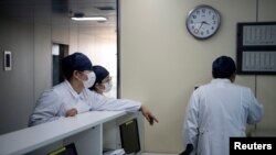 La ciudad de Wuhan informó 72 nuevas muertes el lunes, frente a las 76 del pasado domingo 16 de febrero. Un total de 1,381 personas han muerto allí por el coronavirus. En la imagen, personal médico en Hong Kong dentro de una clínica pública.