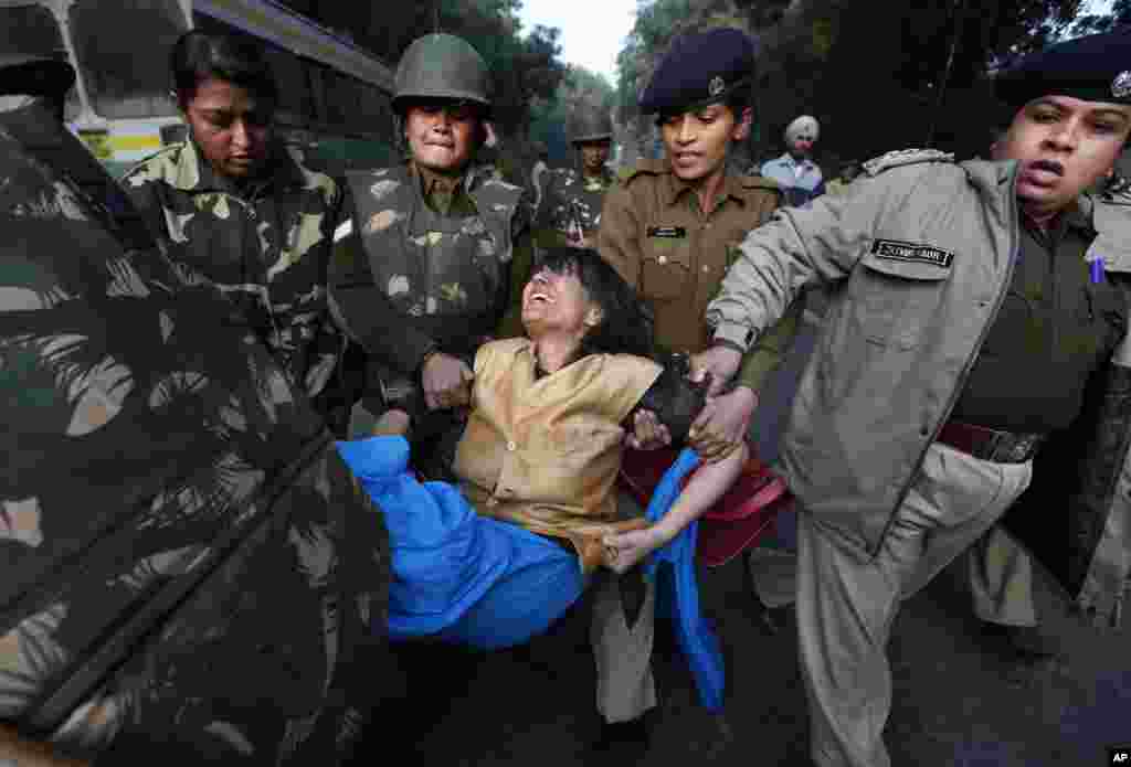 A woman is removed by Indian police while protesting against the brutal gang-rape of a woman on a moving bus in New Delhi, India, December 25, 2012.