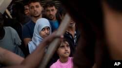 Migrants and refugees rescued by members of Proactive Open Arms NGO wait to leave the Golfo Azzurro rescue vessel at the port of Pozzallo, south of Sicily, Italy, June 17, 2017.