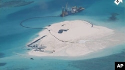 FILE - In this photo taken by surveillance planes and released May 15, 2014 by the Philippine Department of Foreign Affairs, a Chinese vessel, top center, is used to expand structures and land on the Johnson Reef, called Mabini by the Philippines and Chigua by China.