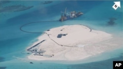 FILE - In this photo taken by surveillance planes and released May 15, 2014 by the Philippine Department of Foreign Affairs, a Chinese vessel, top center, is used to expand structures and land on the Johnson Reef.