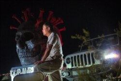 雕塑家陈维明在他的“自由雕塑公园“内守夜（美国之音记者文灏拍摄）