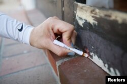 A homeowner uses a home lead test — which turns red when it detects the presence of lead — on the porch door of her old Spanish-style home, valued at more than $1.5 million, and dated from the 1920s, in San Marino, California, April 5, 2017.