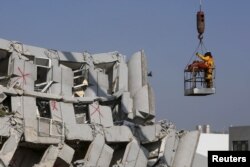 Rescue workers transport a body from the site where a 17-story apartment building collapsed after an earthquake hit Tainan, southern Taiwan, Feb. 7, 2016.