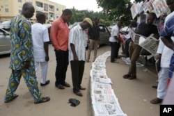 People read newspapers reporting on the release of some of the Chibok school girls, in Abuja, Nigeria, Oct. 14, 2016.