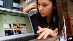 FILE - Nathaly Ordonez studies the home page for the tuition-free, online University of the People, Thursday, Nov. 5, 2015, in New York. (AP Photo/Kathy Willens)