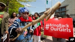 A protester brandishes a wooden stick during a rally in front of the Nigerian embassy in northwest Washington, May 6, 2014, protesting the kidnapping of nearly 300 teenage schoolgirls from a school in the remote northeast of Nigeria three weeks ago.