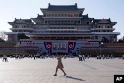A woman walks past the preparations ongoing on Kim Il Sung Square, ahead of the 70th anniversary of North Korea's founding day in Pyongyang, North Korea, Sept. 7, 2018.