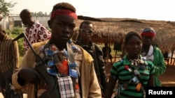 FILE - An anti-balaka child soldier wears lucky charms around his neck in the Ouengo district of Bangui, Central African Republic, Jan. 12, 2014.