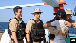 U.S. Navy sailors assigned to the guided-missile destroyer USS Kidd greet a crew member of the Iranian fishing vessel, the AL MOLAI Friday, Jan. 6, 2012 in the Arabian Sea. 