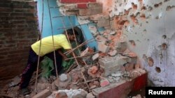  ပါကစ္စတန်ဘက်က တိုက်ခိုက်မှုကြောင့် ပျက်စီးသွားတဲ့အိမ်ကို ပြန်လည်ရှင်းလင်းနေတဲ့ ဒေသခံရွာသားတစ်ဦး။