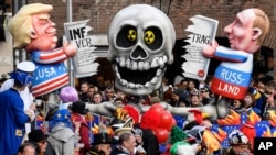 A carnival float depicts Donald Trump and Vladimir Putin cutting the INF Treaty during to the traditional carnival parade in Duesseldorf, Germany, on Monday, March 4, 2019.