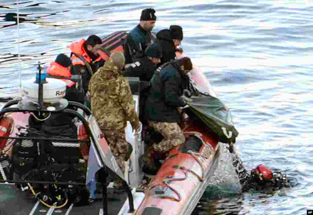 Naval divers recover a body from the cruise ship on Tuesday, raising the official death toll to 11. (AP)