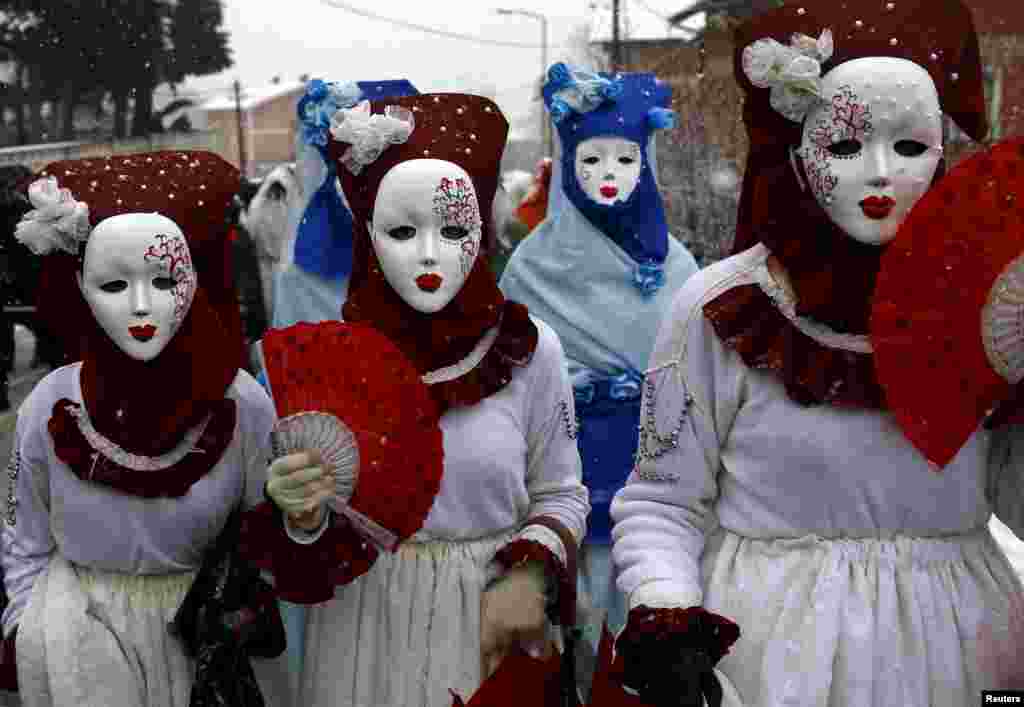 Orang-orang ikut dalam parade di desa Vevcani, sebelah selatan ibukota Makedonia, Skopje. Desa Vevcani memperingati Hari St. Vasilij Ortodoks dengan menyelenggarakan karnaval perayaan asal-usul pagan yang sudah berusia 1.400 tahun.