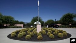 FILE - A security guard talks to a visitor at the entrance to the Annenberg Retreat at Sunnylands in Rancho Mirage, Calif., Wednesday, June 5, 2013.