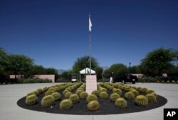 FILE - A security guard talks to a visitor at the entrance to the Annenberg Retreat at Sunnylands in Rancho Mirage, Calif., Wednesday, June 5, 2013.