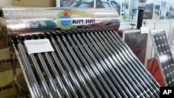 FILE - A solar water heater, left, and a solar panel, right, are seen at Entech Hanoi, an international trade fair on energy efficiency and the environment, at the Giang Vo Exhibition Center in Hanoi, Vietnam.