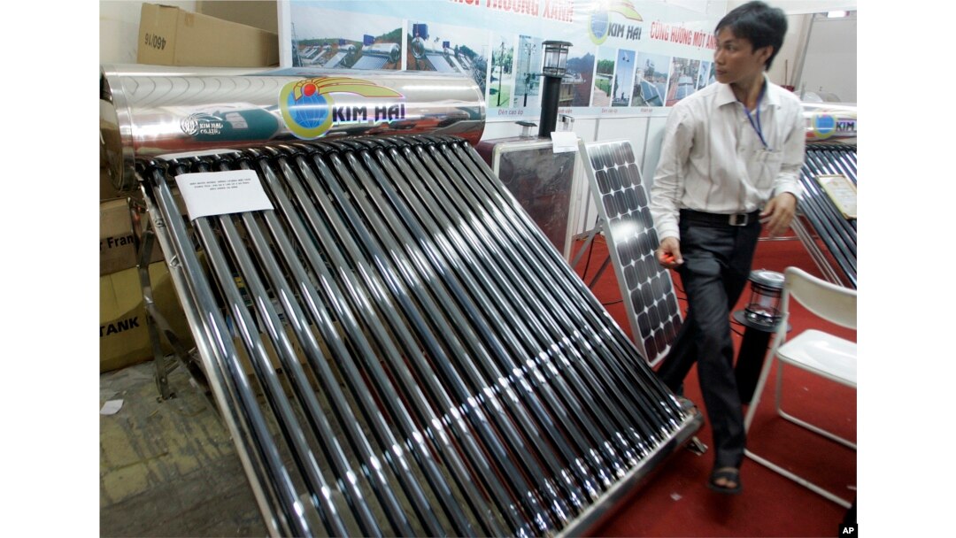 FILE - A solar water heater, left, and a solar panel, right, are seen at Entech Hanoi, an international trade fair on energy efficiency and the environment, at the Giang Vo Exhibition Center in Hanoi, Vietnam.